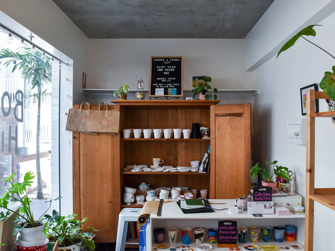 rectangular white wooden table near brown wooden cabinet with ceramic tea set